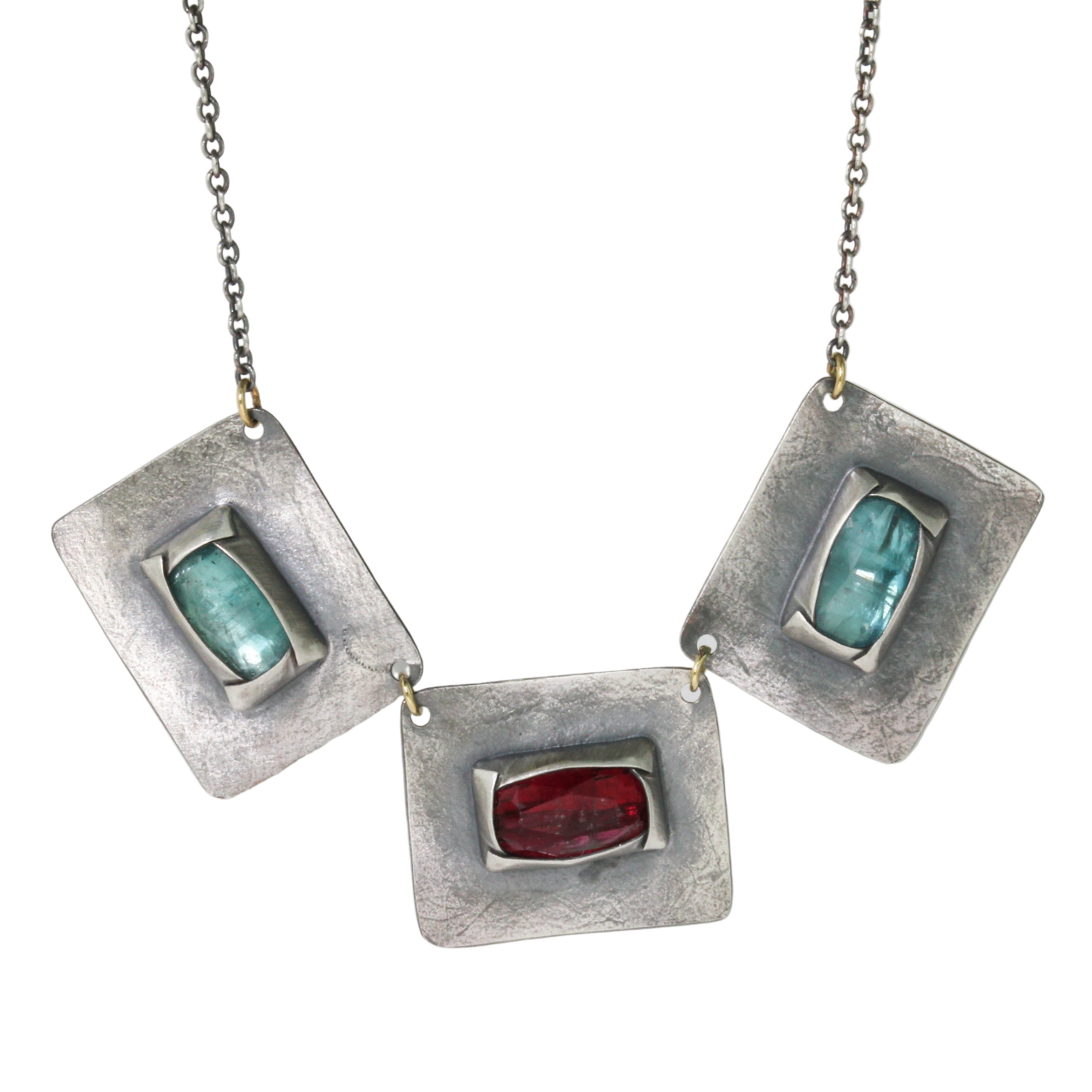 Silver necklace with rectangular pendants featuring teal kyanite and tourmaline stones on a white background