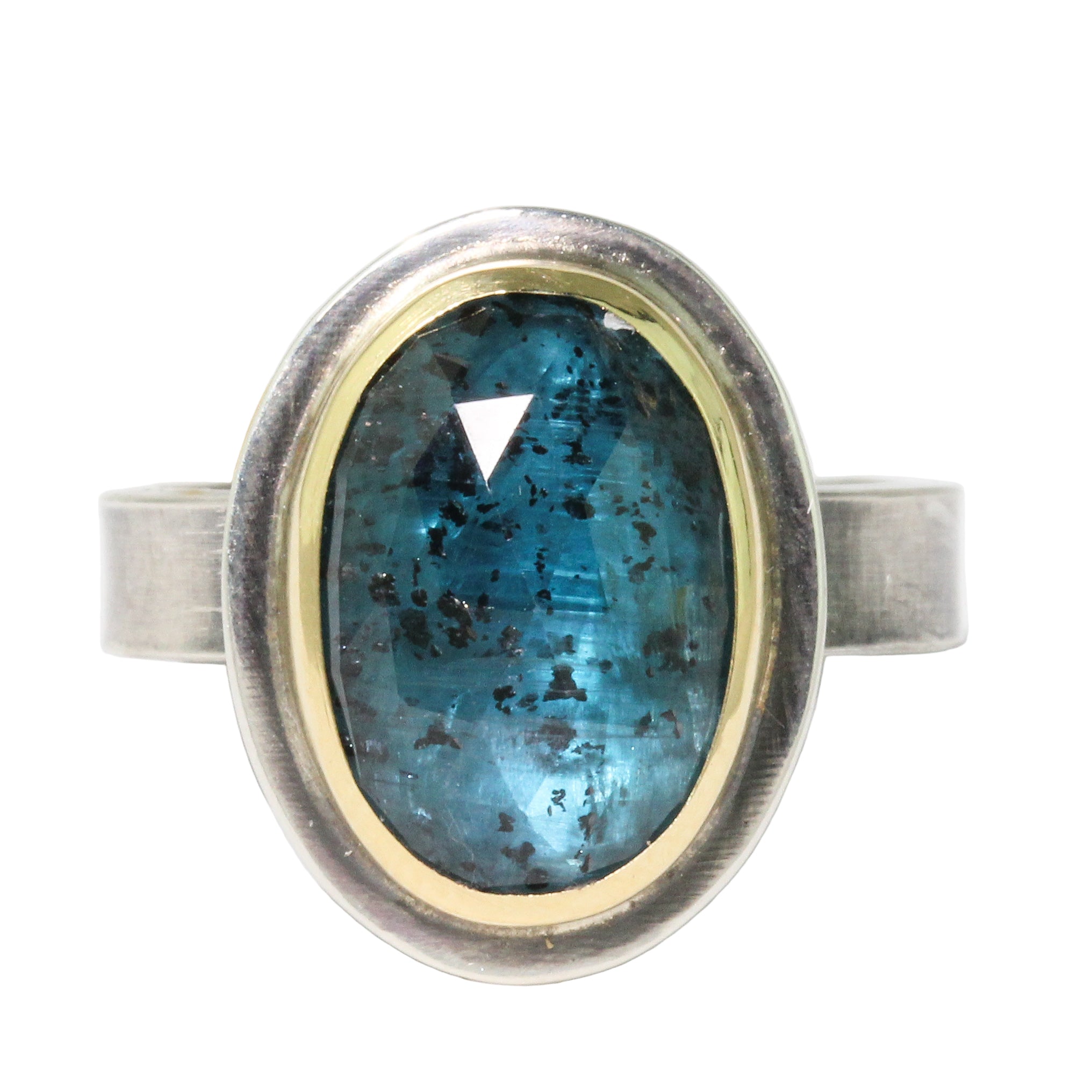 Ring with a blue gemstone and silver and gold band on a white background