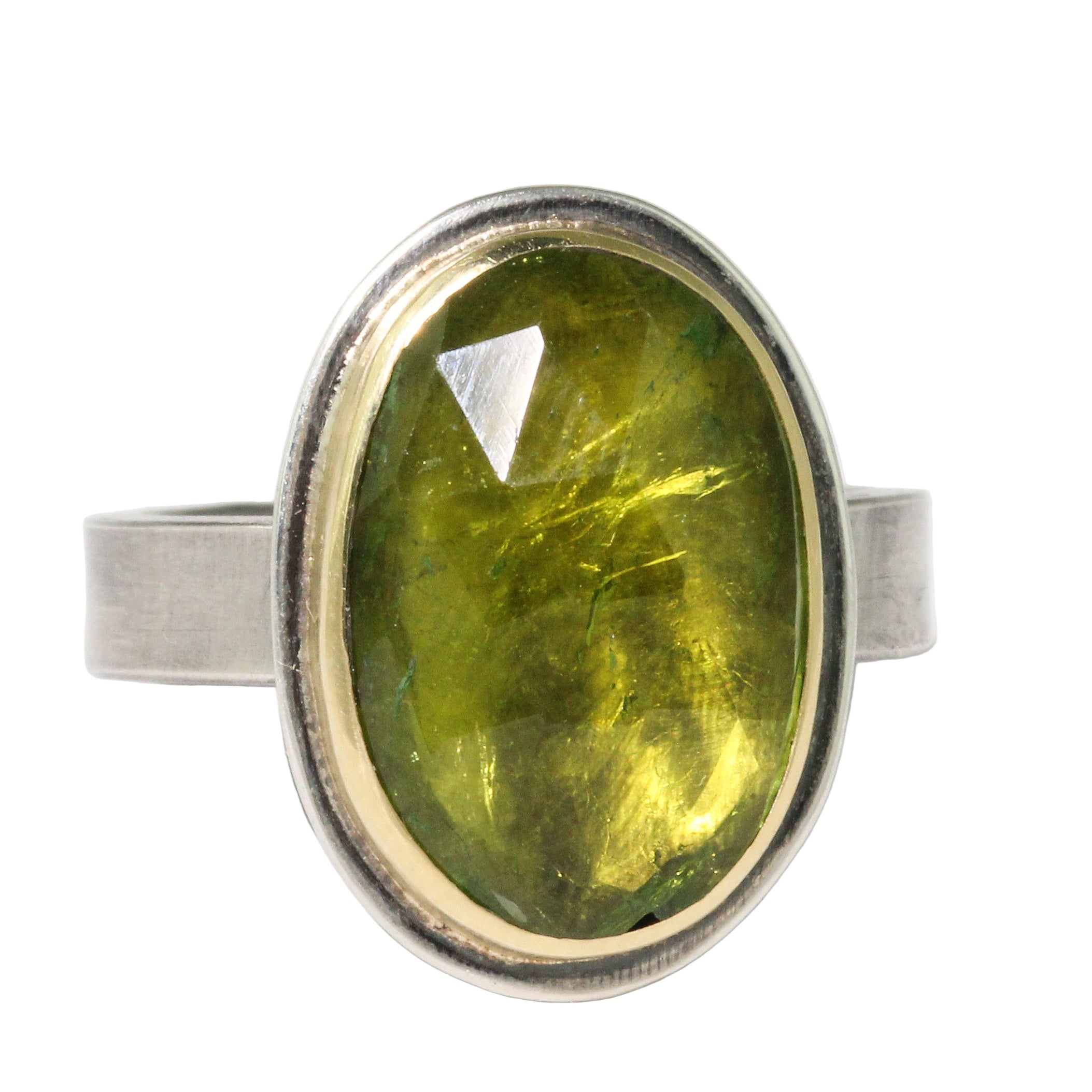 Ring with a green gemstone and silver band on a white background